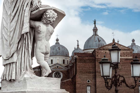 statue holding book on prato della valle in front of saint Guistina Basilicaの写真素材