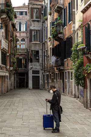 Tourist lost in the empty streets of Venice wearing a corona maskのeditorial素材