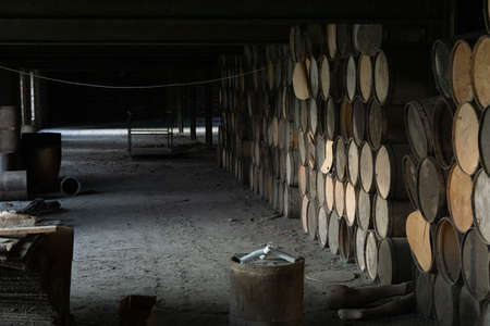 wooden barrels stacked in old abandoned industry buildingの写真素材