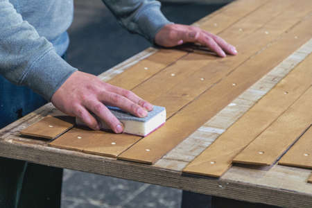 grinding wooden slats by hand in a workshopの写真素材