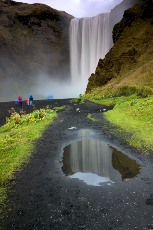 People in colourful jackets looking at Waterfall Skogafossの写真素材