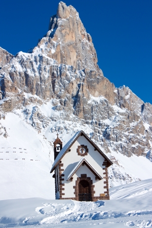 Small church in front of peak in Passo Rolle, Italyの写真素材