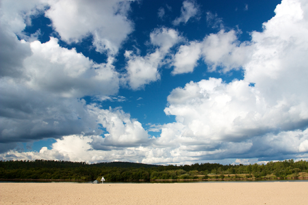 Big clouds on blue sky above Ivalo river in Ivaloの写真素材