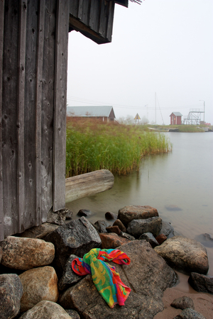 Colourful towel laying on rocks next to wooden cabinの写真素材