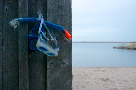 Snorkel and masks hanging on wooden wall on the beachの写真素材