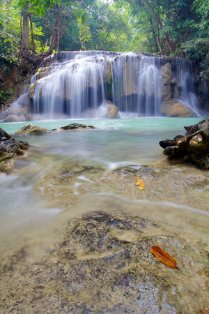 Waterfall in Erawan National Park with orange leaf in foregroundの写真素材