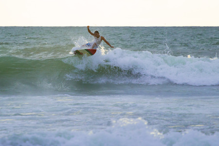 Kuta, Indonesia - January 26, 2014: Indonesian surfer on the top of the breaking wave in Kuta on Bali, Indonesiaのeditorial素材