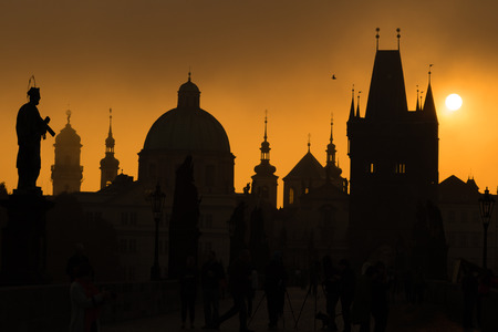 Silhouettes of Prague towers and statues on Charles bridge during sunriseの写真素材