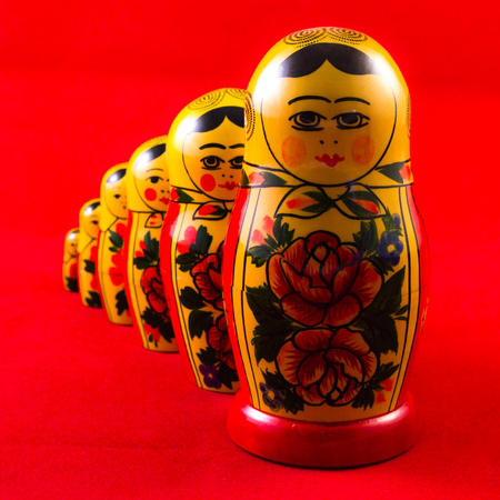 Matryoshka in single file with red backgroundの写真素材