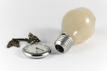 a clock and a light bulb with white backgroundの写真素材