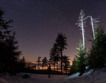 Sky full of stars above man with headlampの写真素材