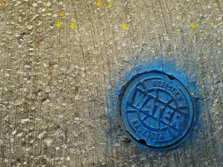 Water drain lid with blue paint on concrete surfaces Tampa Florida