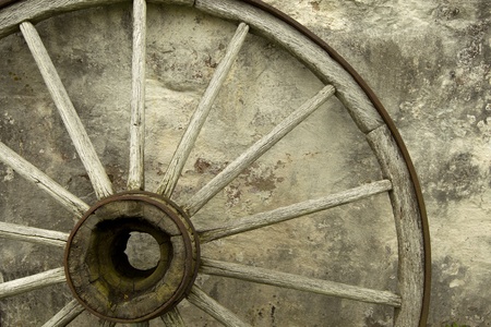 Wagon wheel up against a stone wallの写真素材