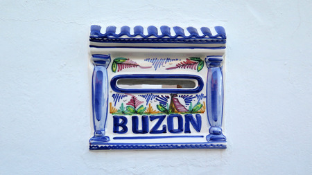 Blue ceramic Spanish letterbox set in patio wall in Alora, Andaluciaの写真素材