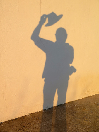 Photographer's shadow against plain concrete wallの写真素材
