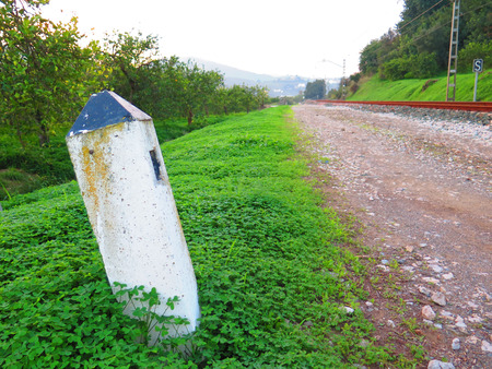 White concrete railway distance marker in weed covered countryside near Alora, Andaluciaの写真素材