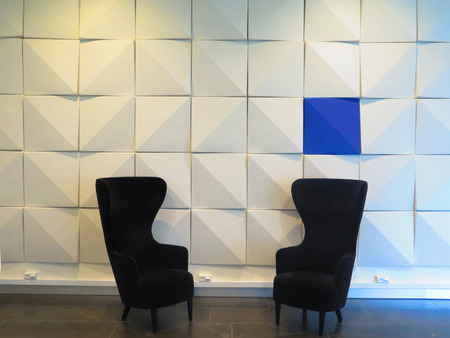 White Decorative wall and two black chairs