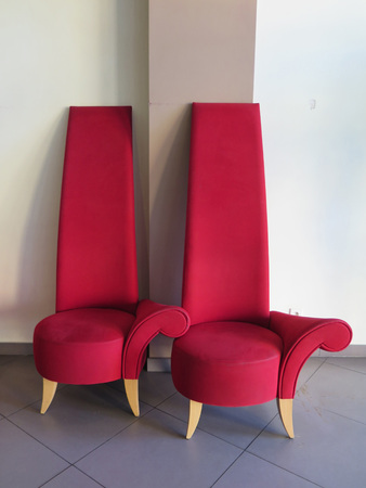 Two one armed red Chairs with tall backrestの写真素材