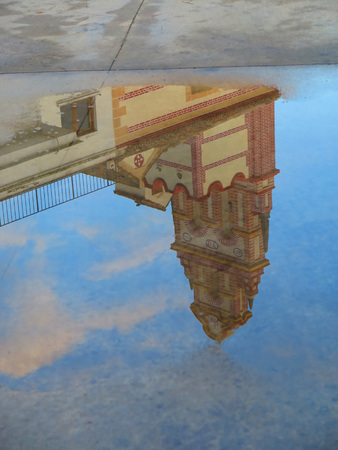 Belfry of Flores convent reflected in large rainwater puddle near Alora, Andaluciaの写真素材