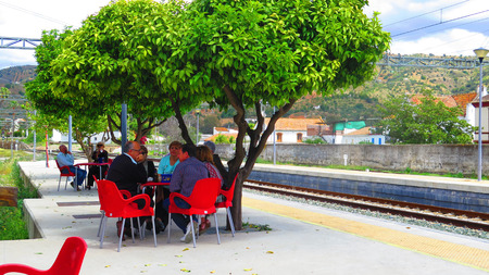 Alora, Spain 23 April 2016: People enjoying Lunch under orange trees on Alora Station Platformのeditorial素材
