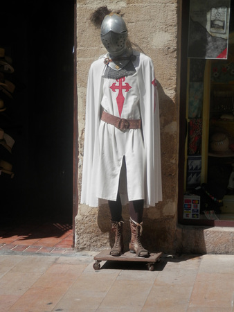 tall white coated mideaval knight on wooden board with wheels