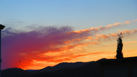 Silhouette at orange dawn clowds in village of Alora Andalusiaの写真素材