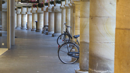Bicycles parked against large columns with christmas decorations in German town of Munsterの写真素材