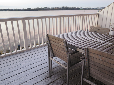 Snow covered wooden terrace by fjord in southern Denmark