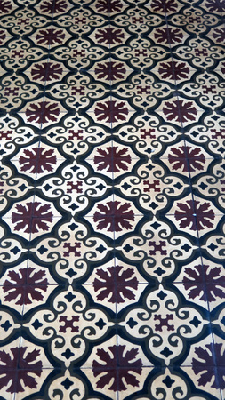 Brown and white floor tiles with floral design in Andalusian village house