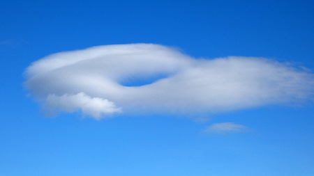 Single cloud with hole over Andalusian hills in winter sunshineの写真素材
