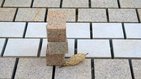 Stacked paving stones and roll of guide string on newly laid road surface in Andalusian villageの写真素材
