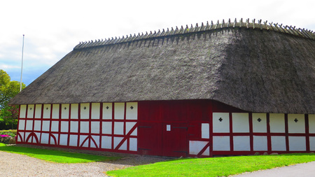 Holm, Denmark - May 27, 2019: Thatched half timbered building on cobbled street in old Southern Danish villageのeditorial素材