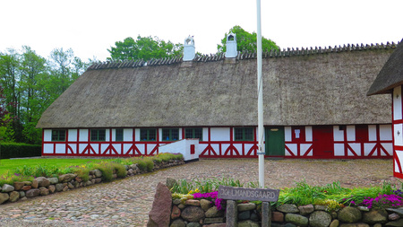 Holm, Denmark - May 27, 2019: Thatched half timbered building on cobbled street in old Southern Danish villageのeditorial素材