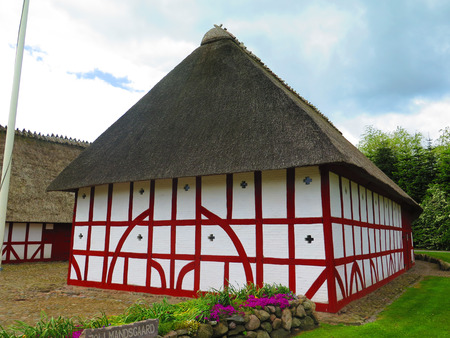 Holm, Denmark - May 27, 2019: Thatched half timbered building on cobbled street in old Southern Danish villageのeditorial素材