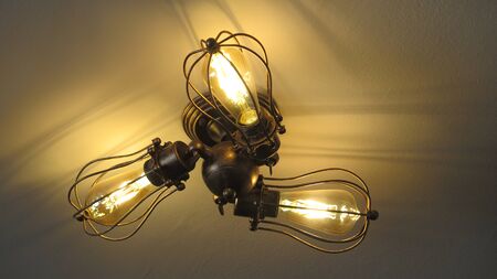Ceiling light with three bulbs in old style metal fittingsの写真素材