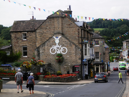 Pateley Bridge, England - August 4, 2019: Symbol of 'Tour de Yorkshire' on building in small villageのeditorial素材
