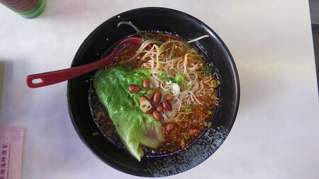 Bowl of bean and noodle soup with cabbage and dumplings served for breakfast in Kowloon restaurant, Hong Kongのeditorial素材