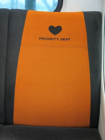Bright orange priority seats on Japanese public transport in Tokyoの写真素材