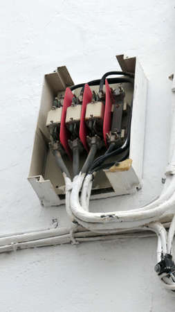 Wall mounted junction box without cover on Andalusian village wall