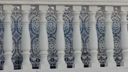 Decorative blue wall tiles through white balcony balustradeの写真素材