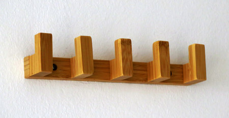 Simple wooden coat rack on white wall