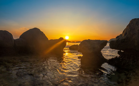 Beach and rocks in seaside. Beautiful dramatic ocean sunsetの写真素材