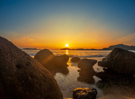 Beach and rocks in seaside. Beautiful dramatic ocean sunsetの写真素材