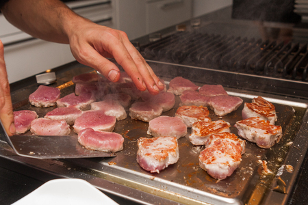 cook turn around grilled tuna meat on metallic panの写真素材