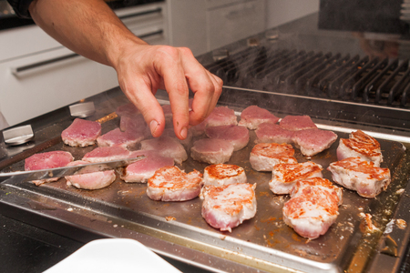 cook turn around grilled tuna meat on metallic panの写真素材