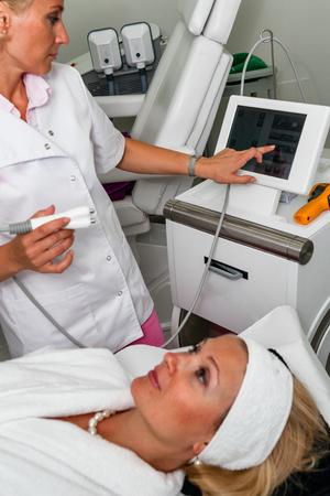 TENERIFE, Spain, July 2014: Aesthetic medicine and cosmetology. Doctor make ultrasonic peeling on patient face in beauty clinic on Adeje Sur.のeditorial素材