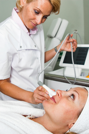 TENERIFE, Spain, July 2014: Aesthetic medicine and cosmetology. Doctor make ultrasonic peeling on patient face in beauty clinic on Adeje Sur.のeditorial素材