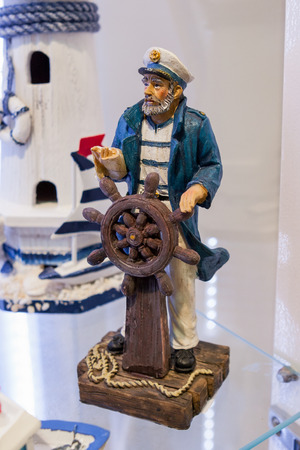 miniature ceramic statue of old captain with steering wheelの写真素材