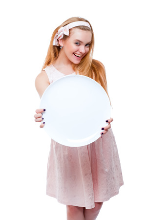 Blond young woman in light dress isolated on white background holding big round dishの写真素材