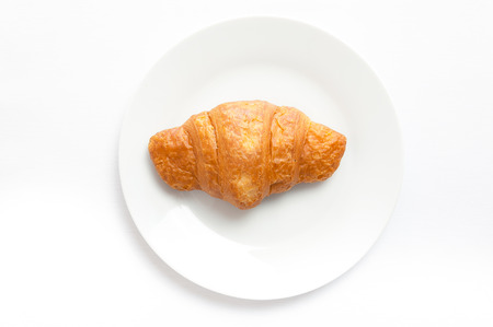 Croissant on white plate, top view. Sweat baked dessert in a dish.の写真素材